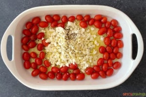 tomatoes and feta drizzled with olive oil in baking dish