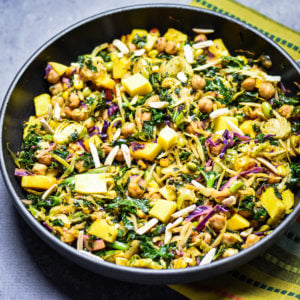 Chickpeas kale salad in pan topped with mango chunks