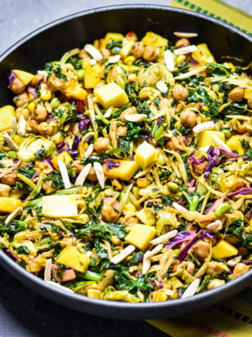 Chickpeas kale salad in pan topped with mango chunks