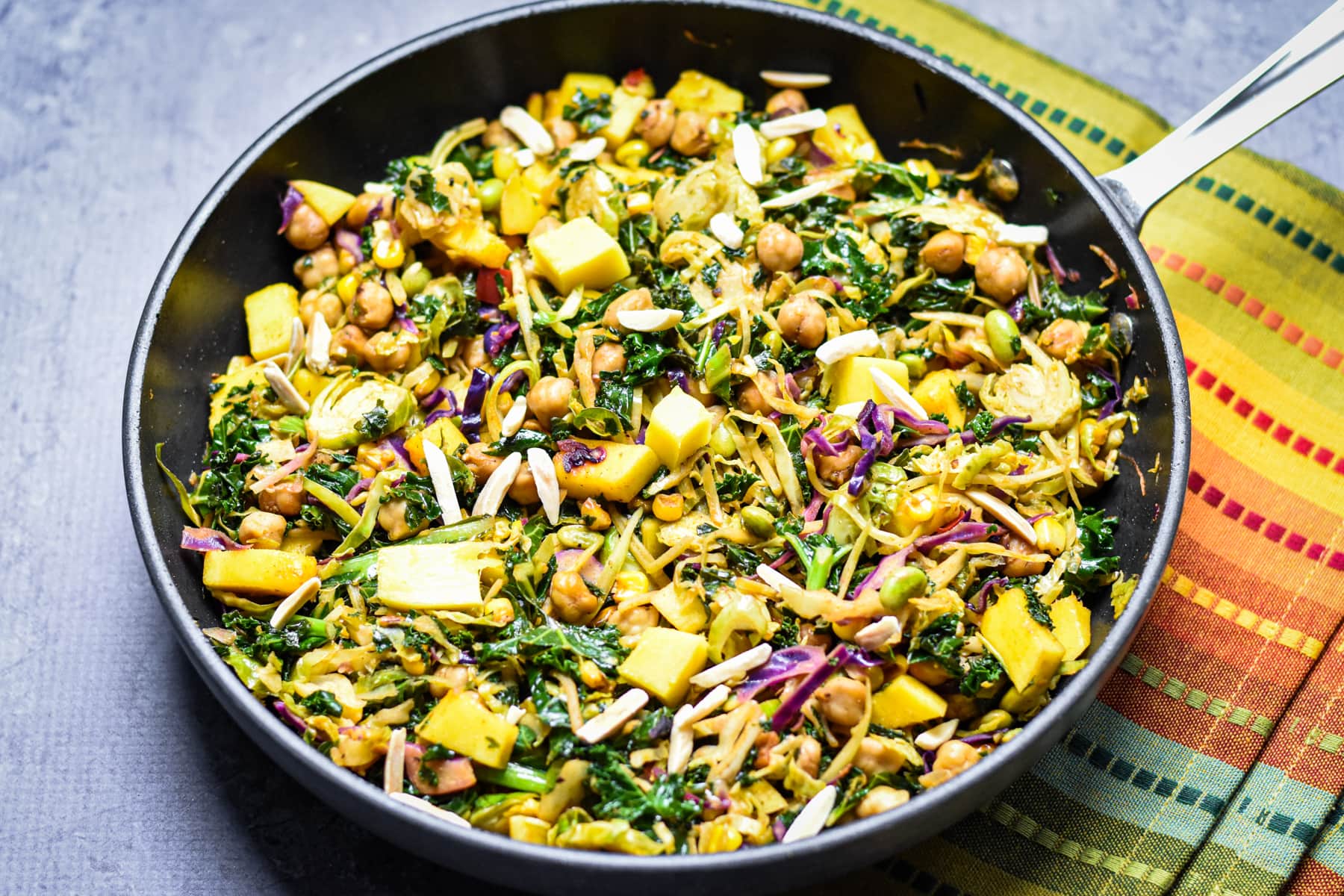 Kale and chickpea salad with mango in a frying pan