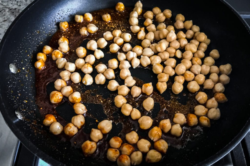Chickpeas in a frying pan with oil and spices
