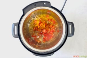chopped tomato and seasonings in instant pot with sautéed onion