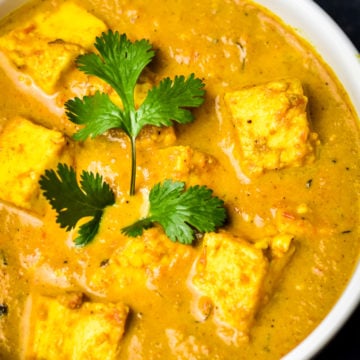bowl of paneer butter masala garnished with fresh cilantro