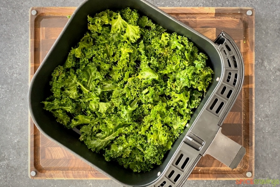 Kale leaves in air fryer basket