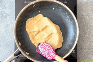 Making dough in non-stick skillet with purple spatula