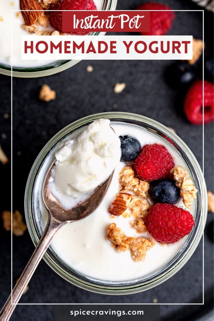 Scooping yogurt from cup topped with granola and berries