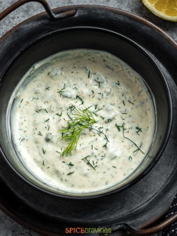 serving dish of lemon caper sauce with fresh dill