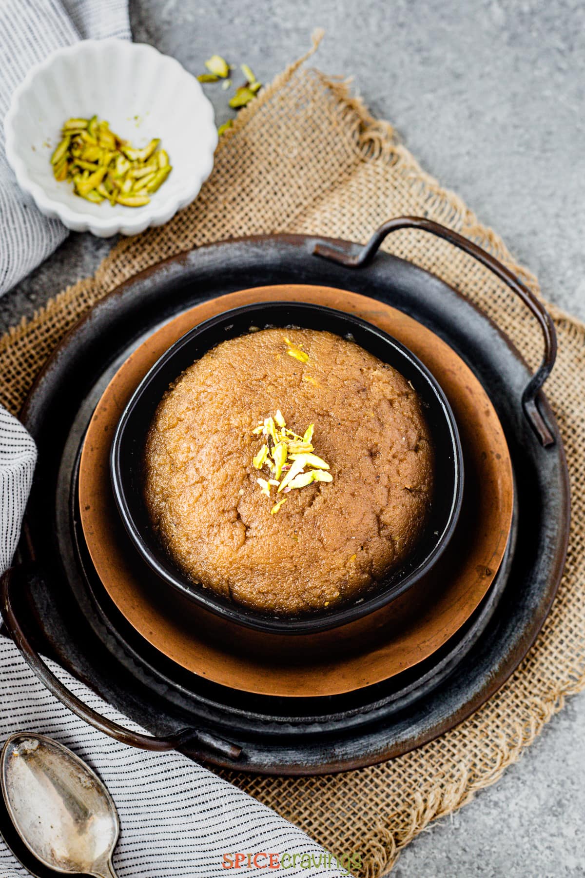Bowl of atta halwa garnished with pistachio slivers