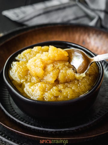 Scooping Indian halwa from a bowl