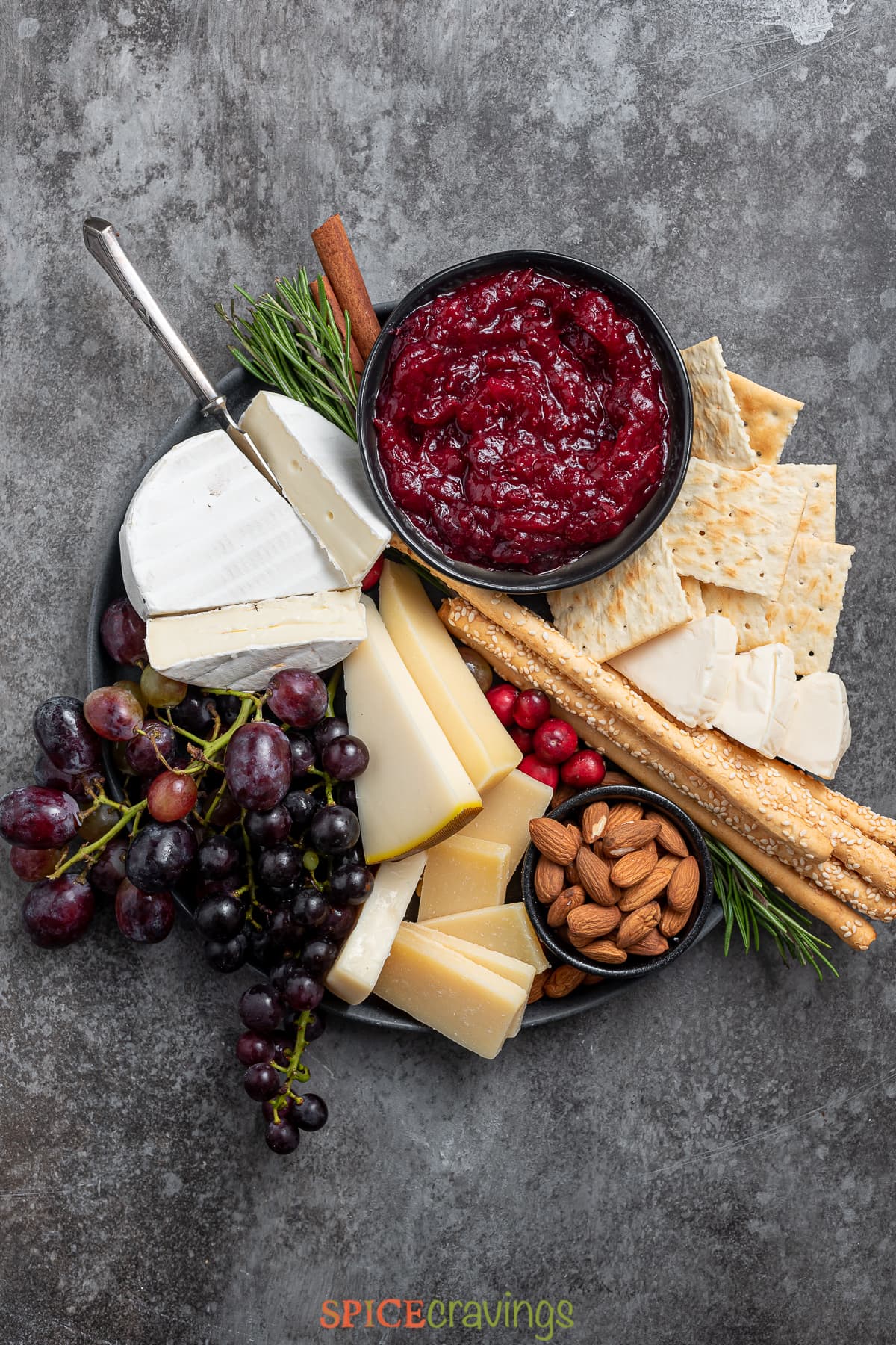 cheese plate served with a bowl of cranberry chutney