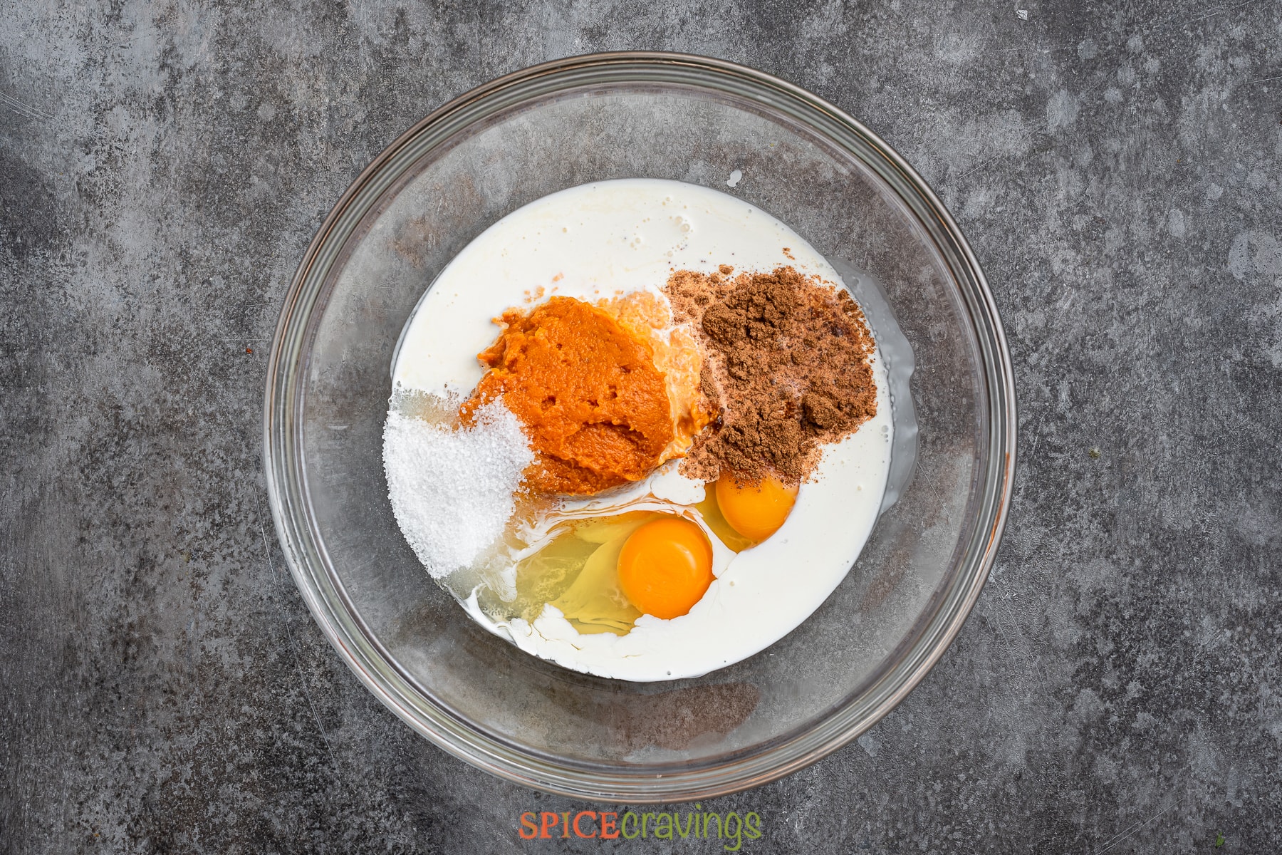 Pumpkin puree, eggs, spice, half and half in a glass bowl