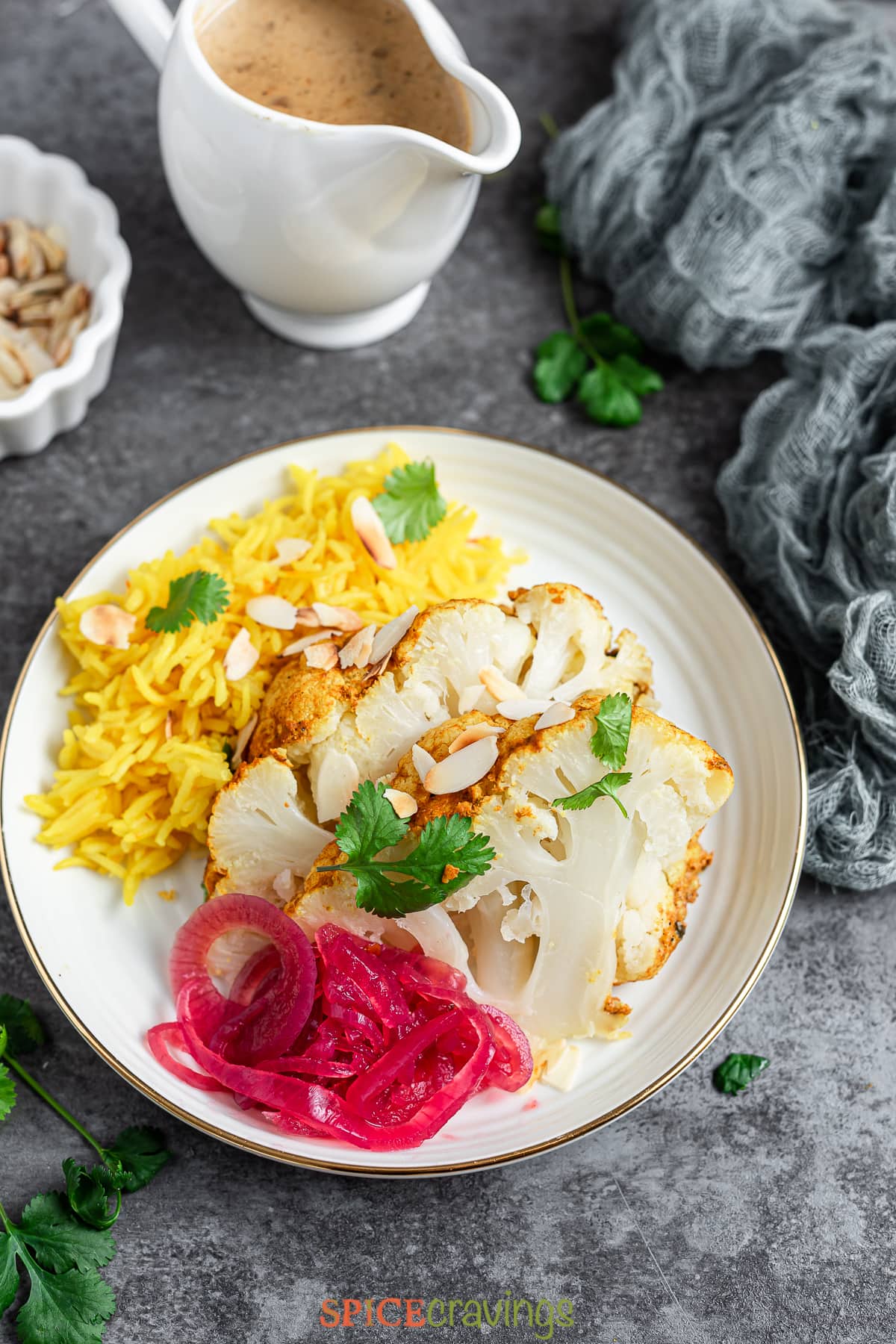 Plate with cauliflower steaks, pickled onion and saffron rice