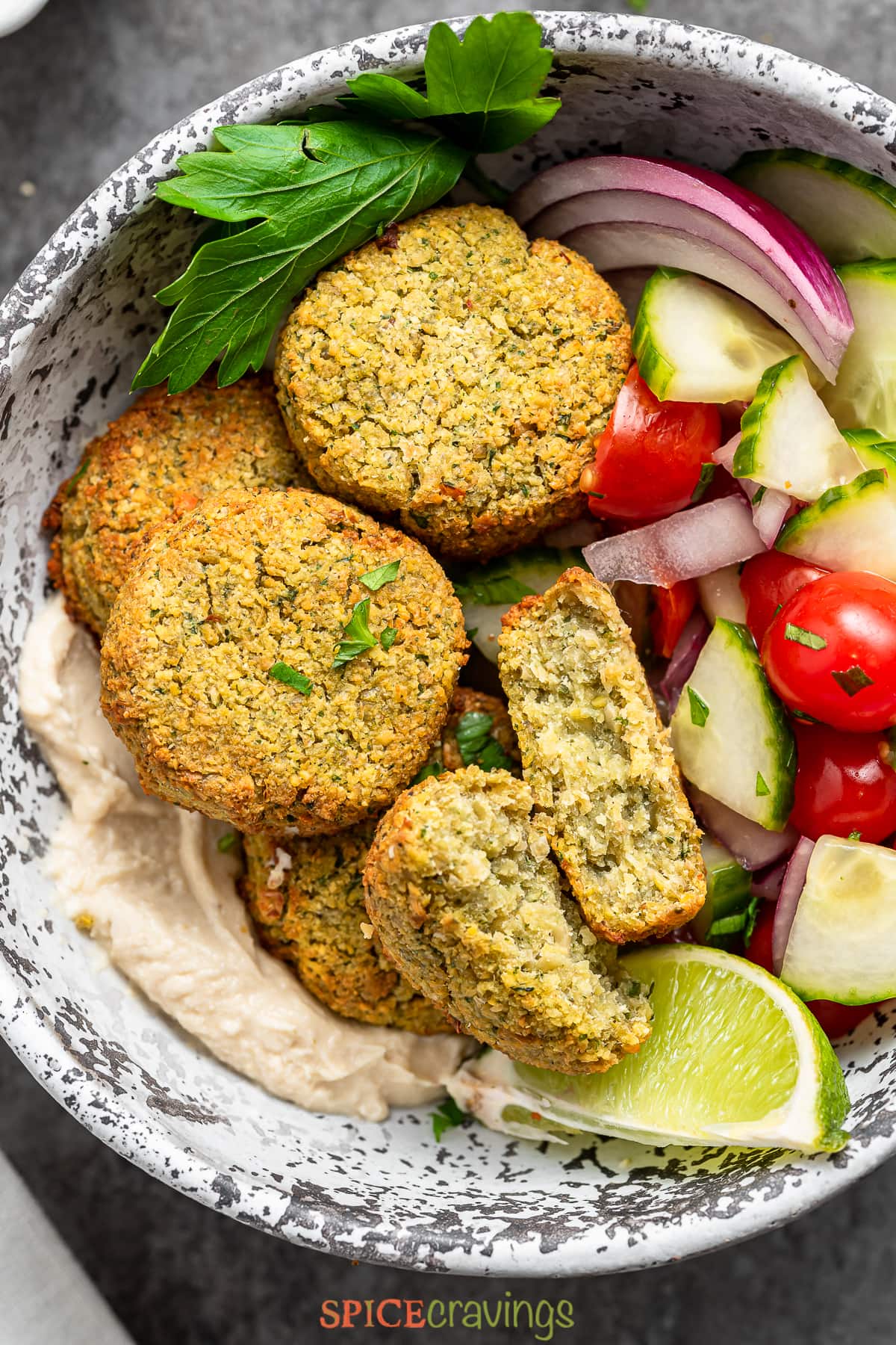 air fried falafel patties in a bowl with hummus and fresh veggies