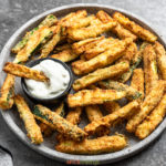 air fried zucchini fries on large platter with tartar sauce on side