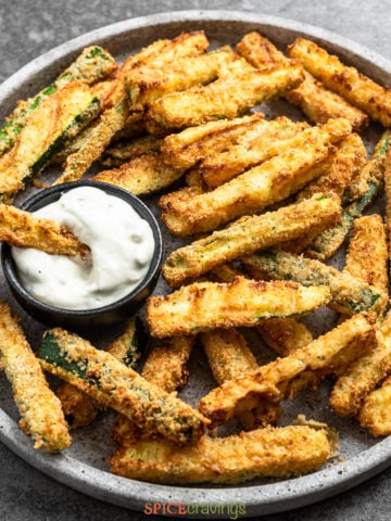 air fried zucchini fries on large platter with tartar sauce on side