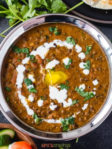 madras lentils in a bowl garnished with cream, butter and cilantro