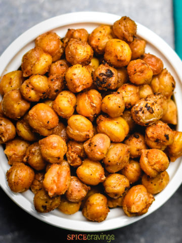 roasted chickpeas in a small white bowl with blue green towel