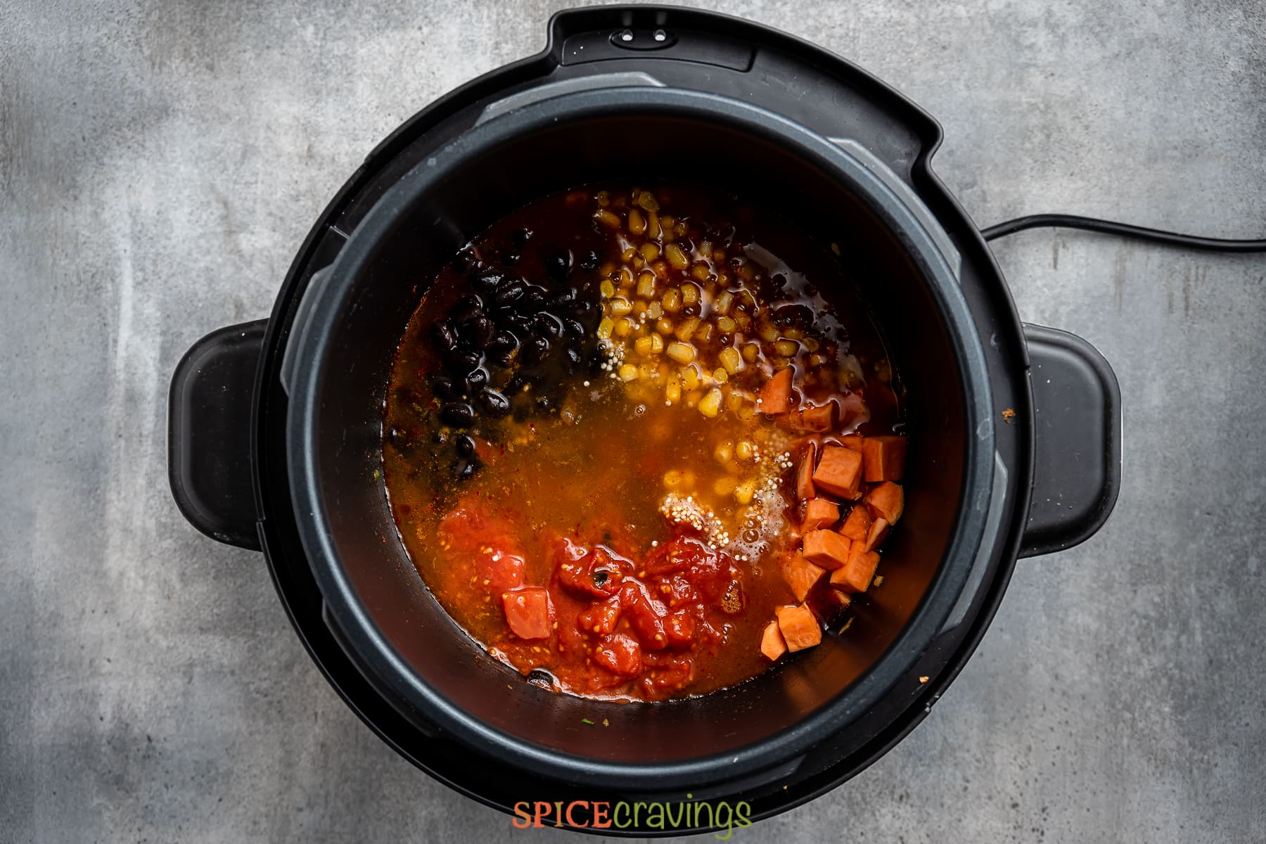 broth added to the instant pot along with tomato, sweet potato, corn and beans