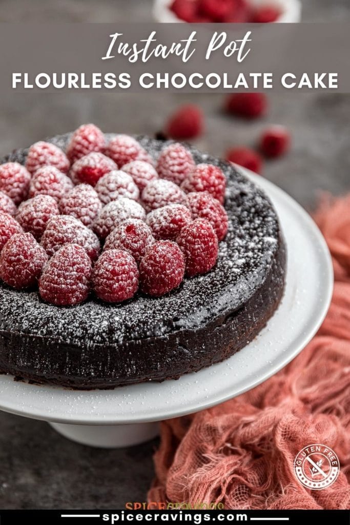 easy flourless chocolate cake topped with raspberries on cake stand