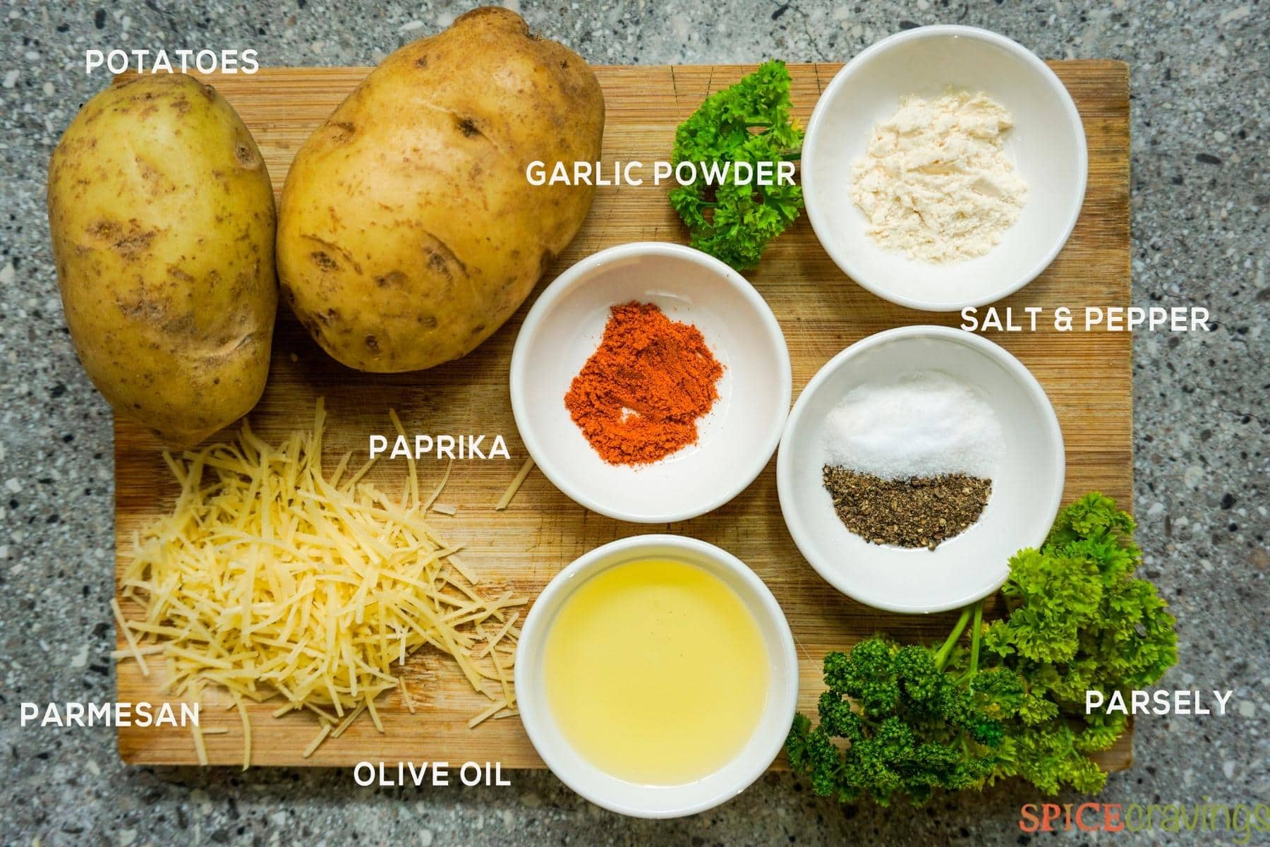 Potatoes, spices, cheese and parsley on cutting board