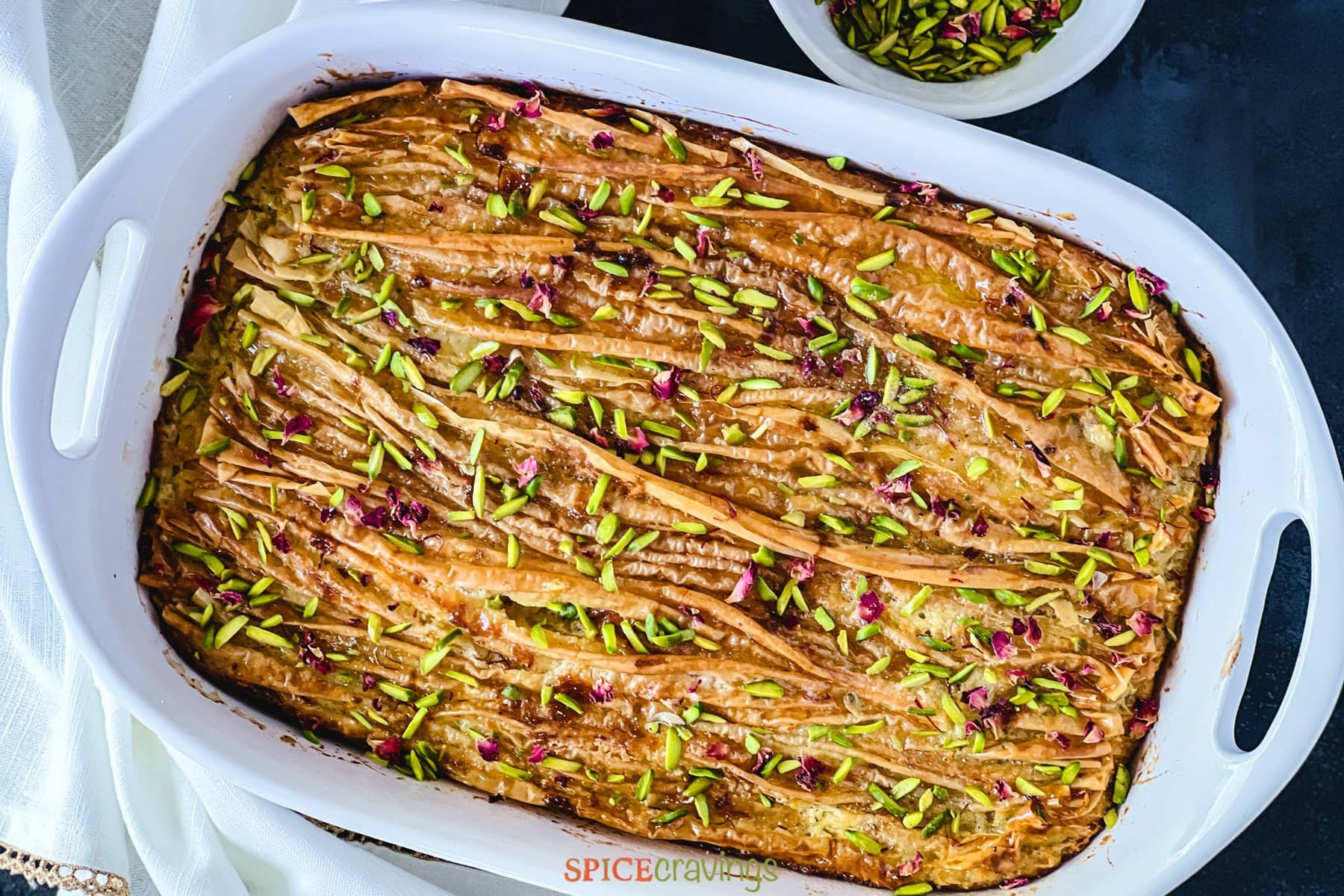 Baked crinkle cake topped with pistachios and rose petals