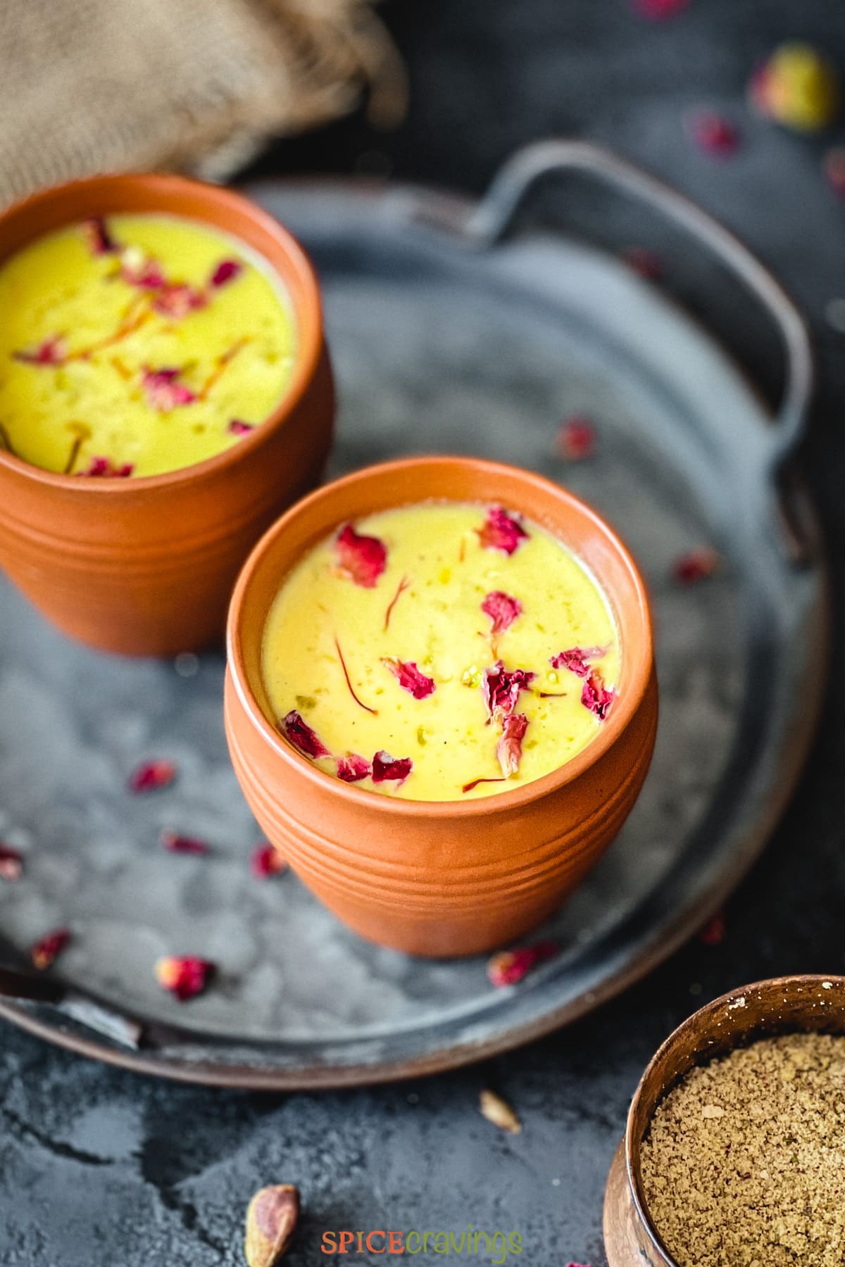 Indian sweetened milk with rose petals in clay cup