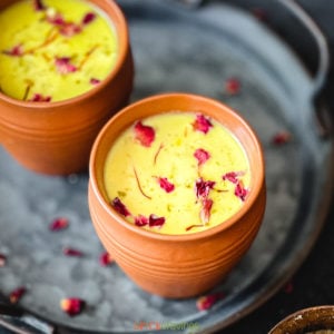 Clay cups with Indian flavored milk called Thandai, garnished with rose petals