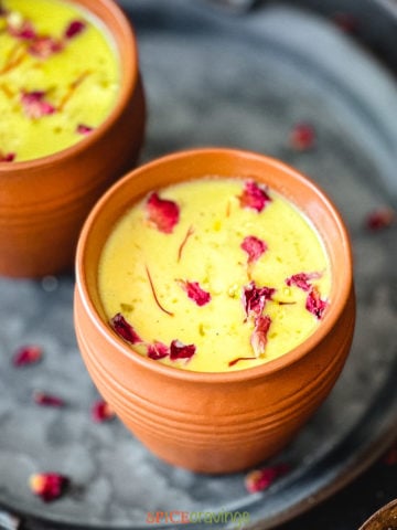 Clay cups with Indian flavored milk called Thandai, garnished with rose petals