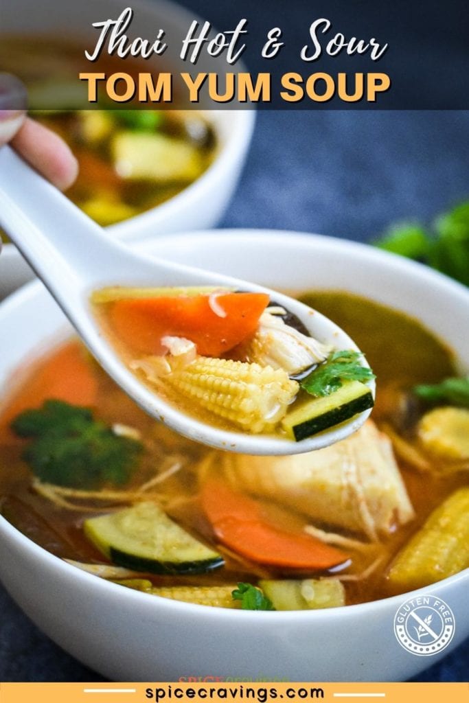 Soup spoon loaded with baby corn, carrot, chicken and zucchini