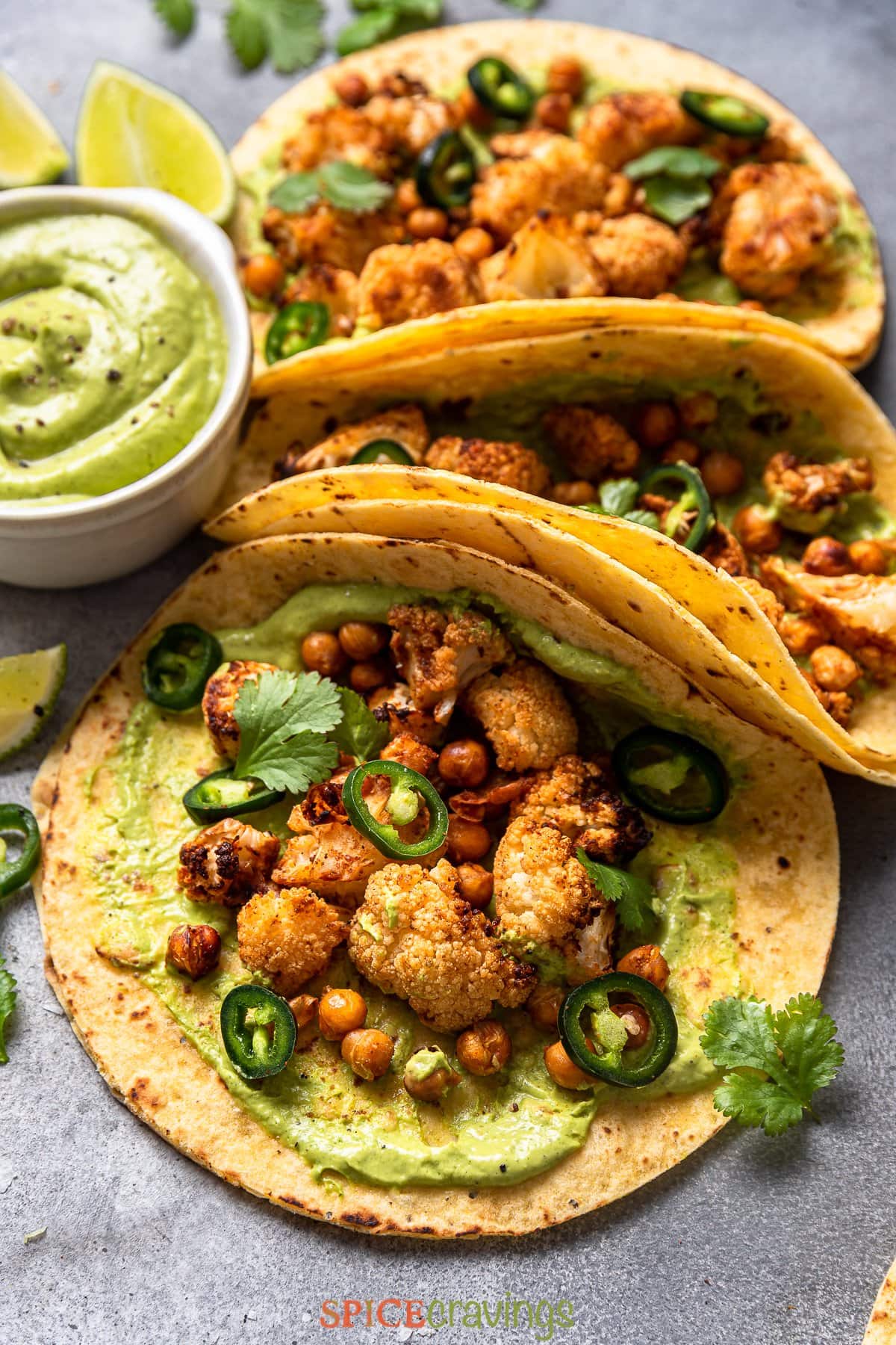 three cauliflower tacos with chickpeas and green goddess sauce on side