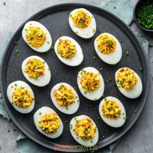 easy spiced deviled eggs arranged on black platter