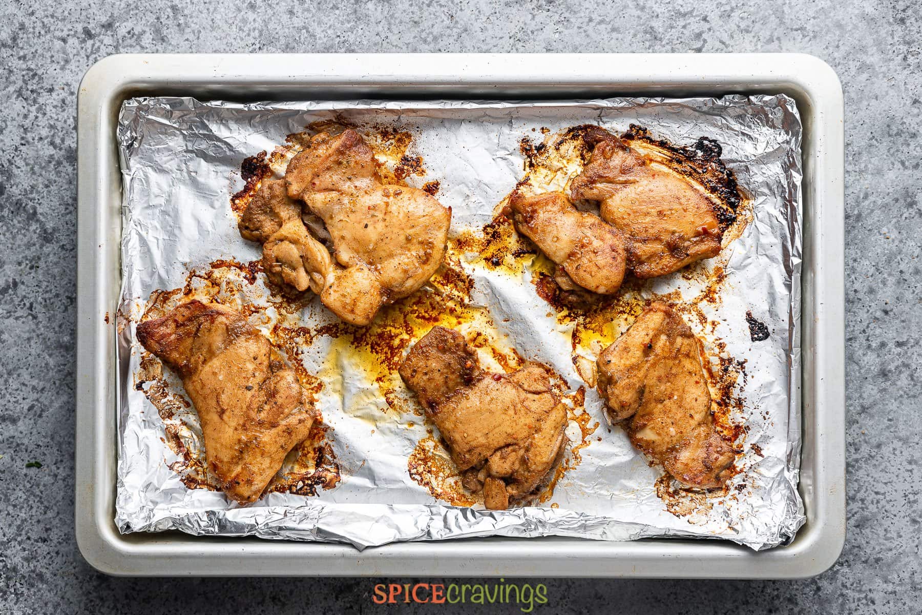 recipe for Greek chicken on aluminum lined baking sheet