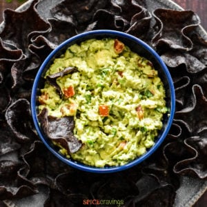 Bowl with guacamole surrounded with blue corn chips