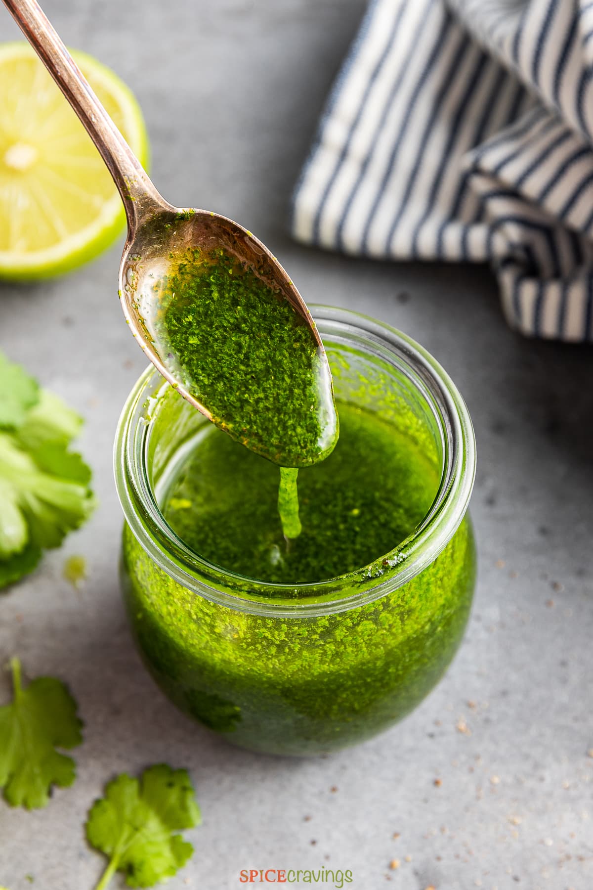 cilantro vinaigrette in glass jar with spoon dipping in