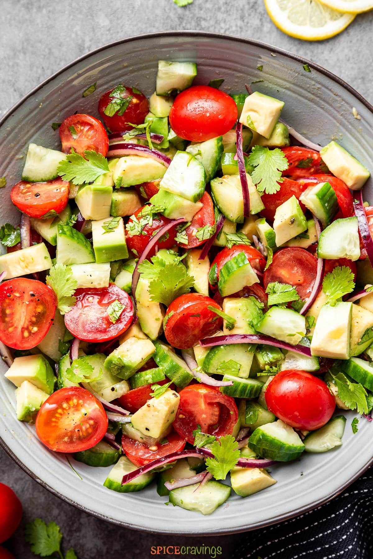 chopped cucumber, tomato, avocado salad in large bowl