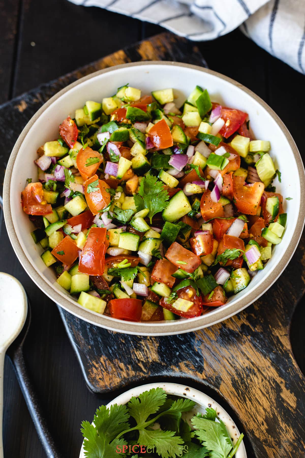 chopped salad made of cucumber, tomato, onion and cilantro