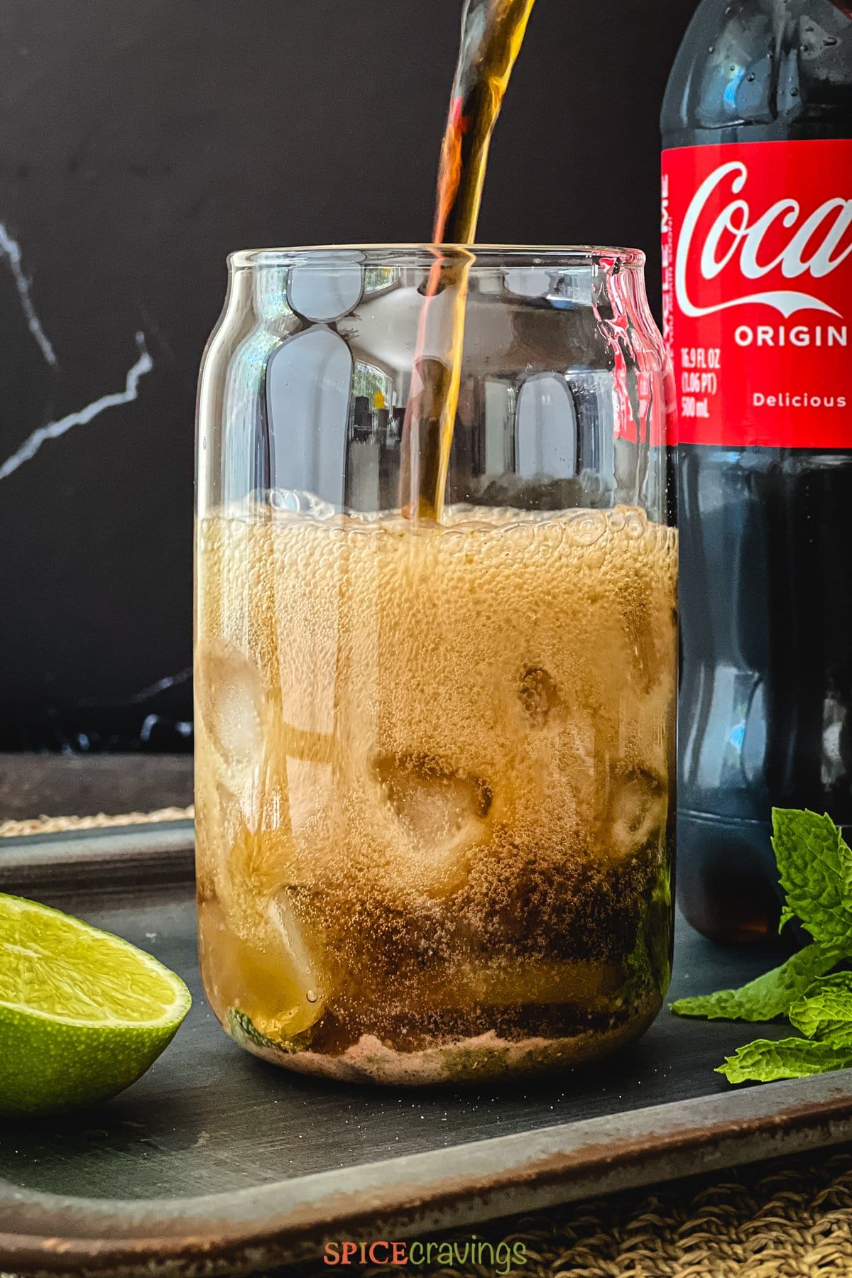 Pouring coke over ice in a glass