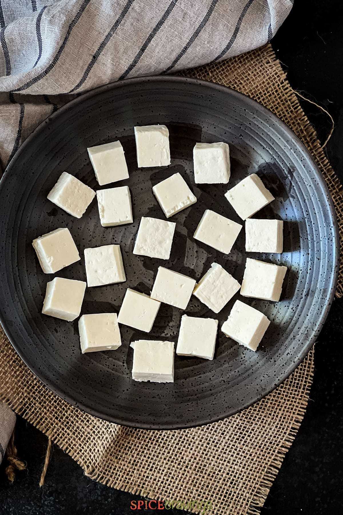 paneer cubes spread out on black plate