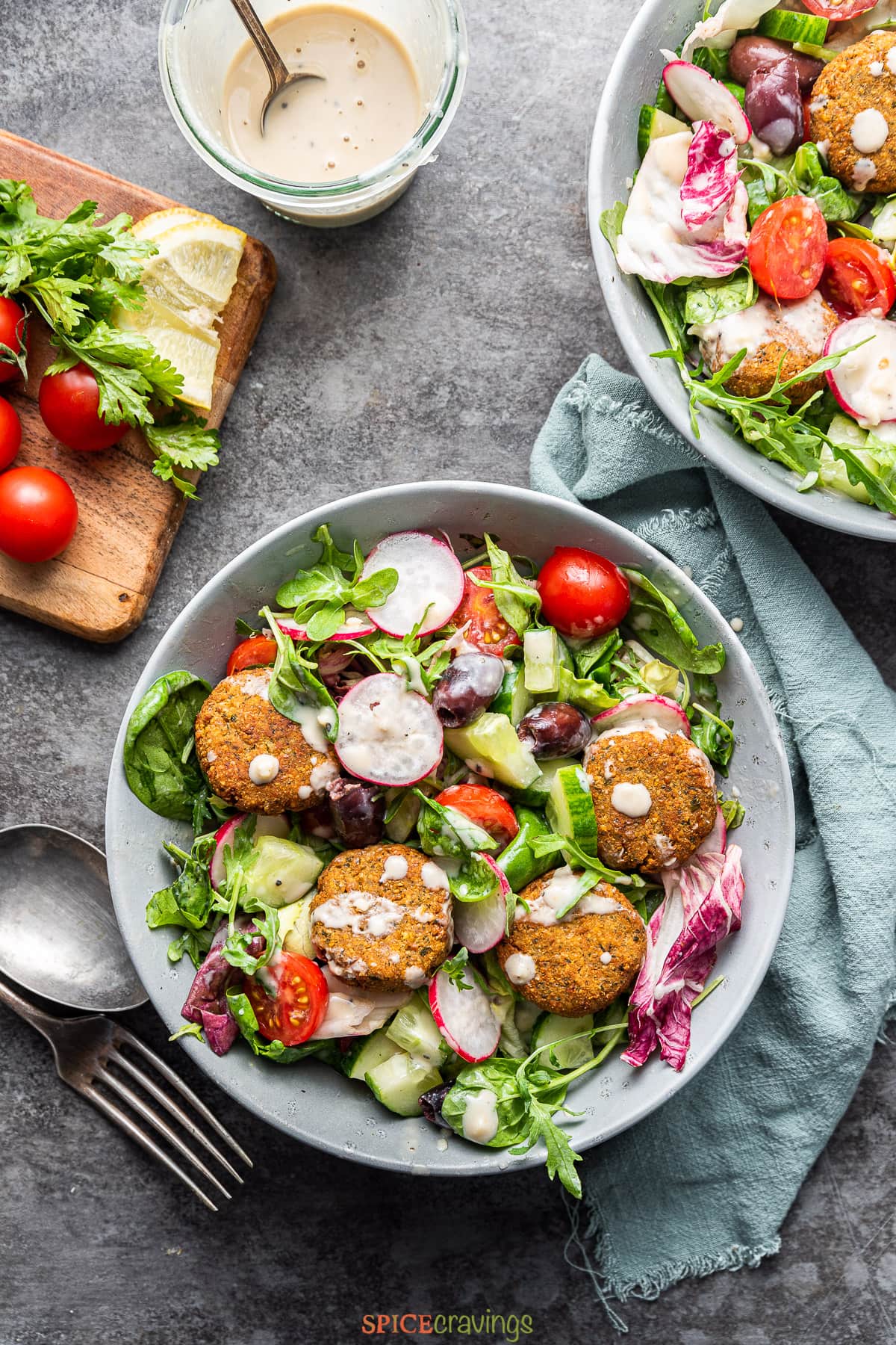 falafel salad in bowl with radish and dressing drizzled on top