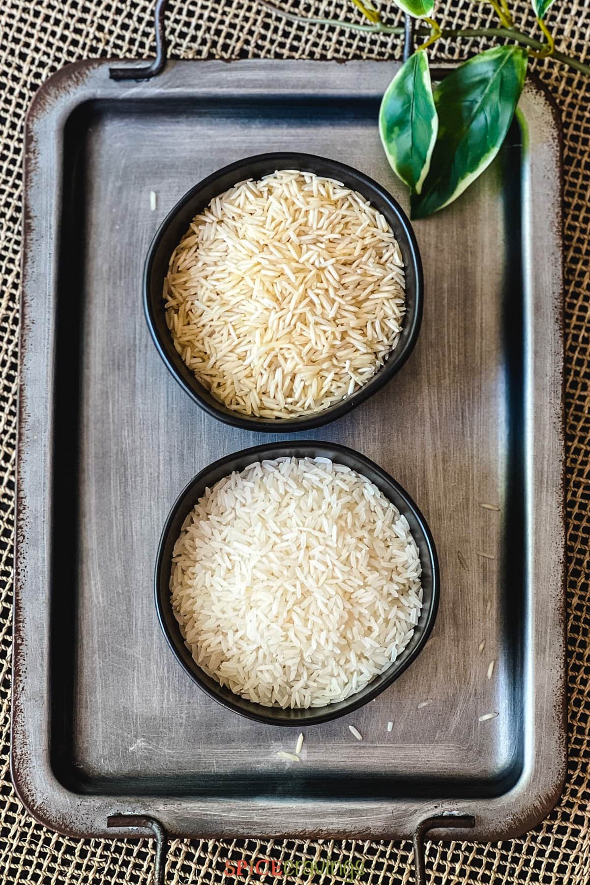 basmati rice and jasmine rice in two separate black bowls on metal serving platter