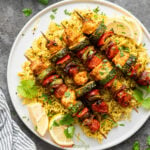 Chicken and vegetables skewers served over yellow rice