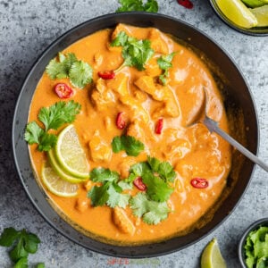 chicken coconut curry in black bowl with spoon