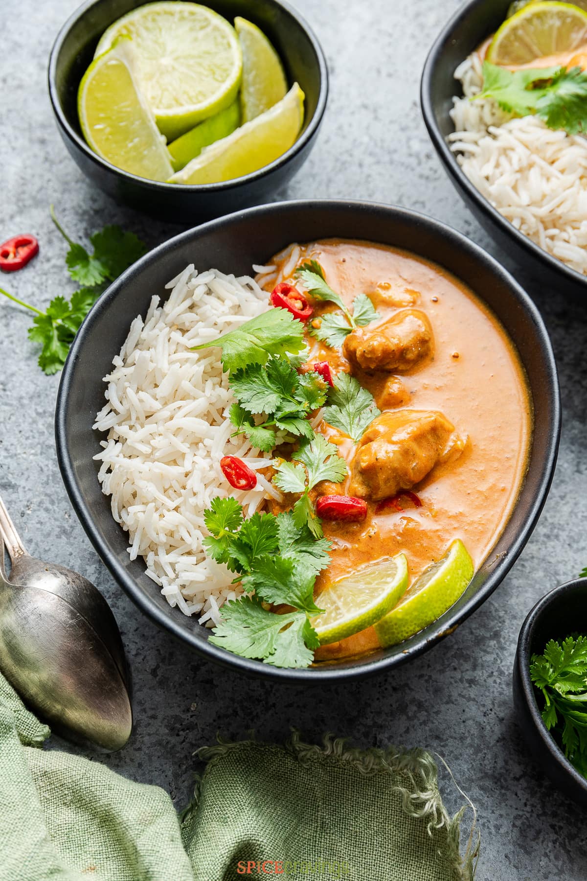 chicken coconut curry over rice in black bowl