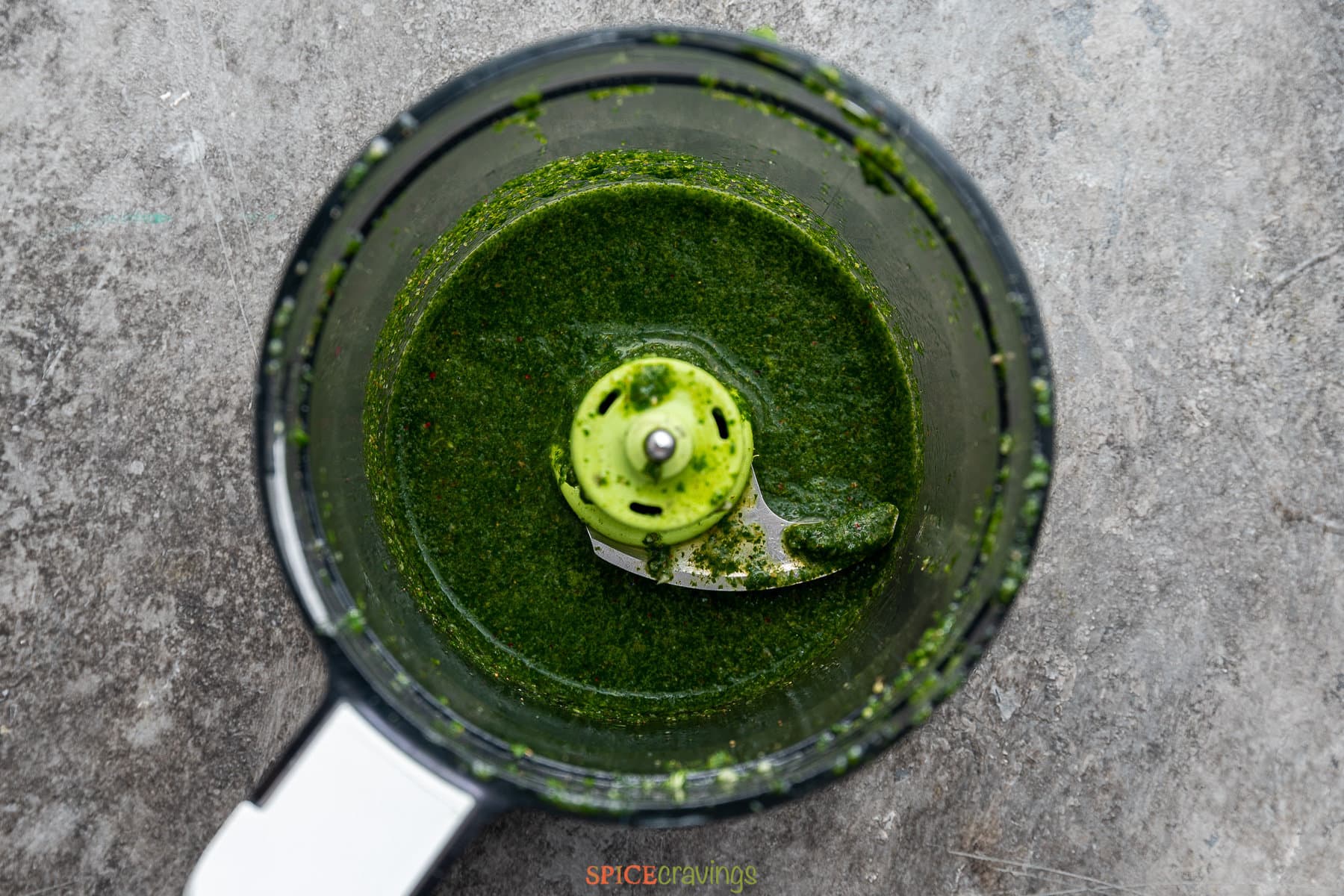 Blended green sauce in food processor jar
