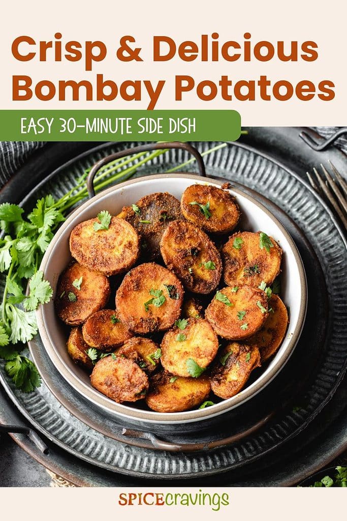 Spiced roasted potatoes in metal plates with cilantro on the side