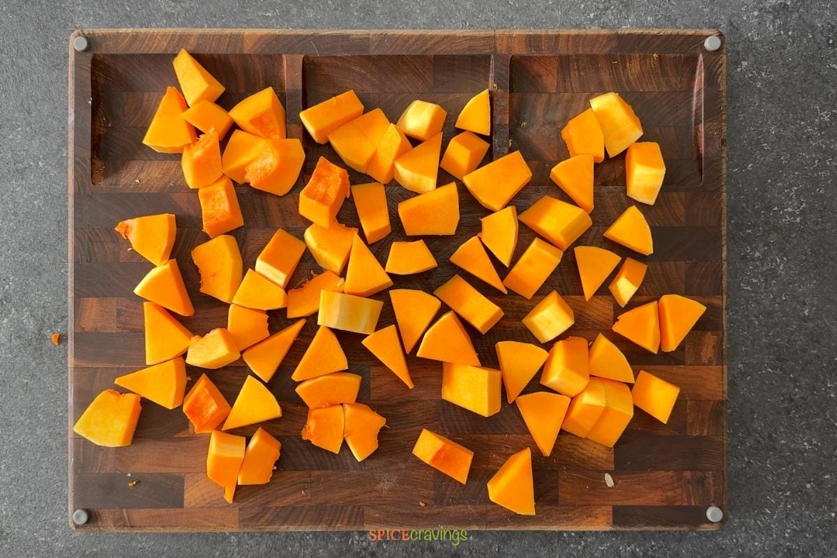 cut up cubes of butternut squash on wooden tray