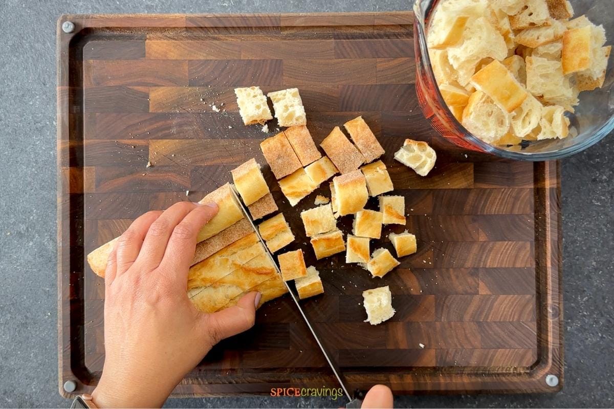 Cutting bread cubes on wooden board