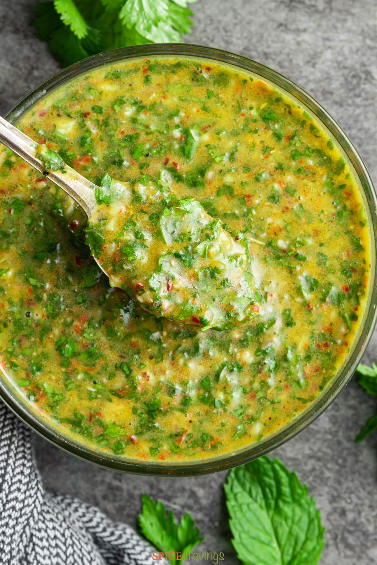 chimichurri cilantro sauce in glass bowl with spoon