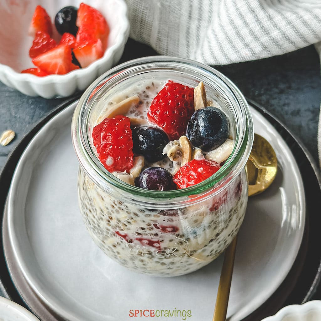 overnight oats chia seed recipe in glass jar topped with berries and nuts