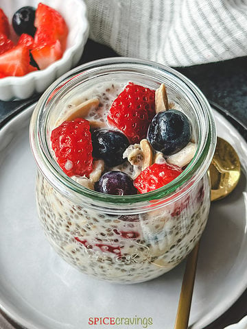 overnight oats chia seed recipe in glass jar topped with berries and nuts